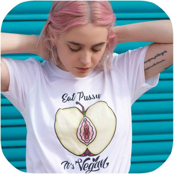 modelo posando con una camiseta blanca con una manzana cortada a la mitad que pone eat pussy, it's vegan
